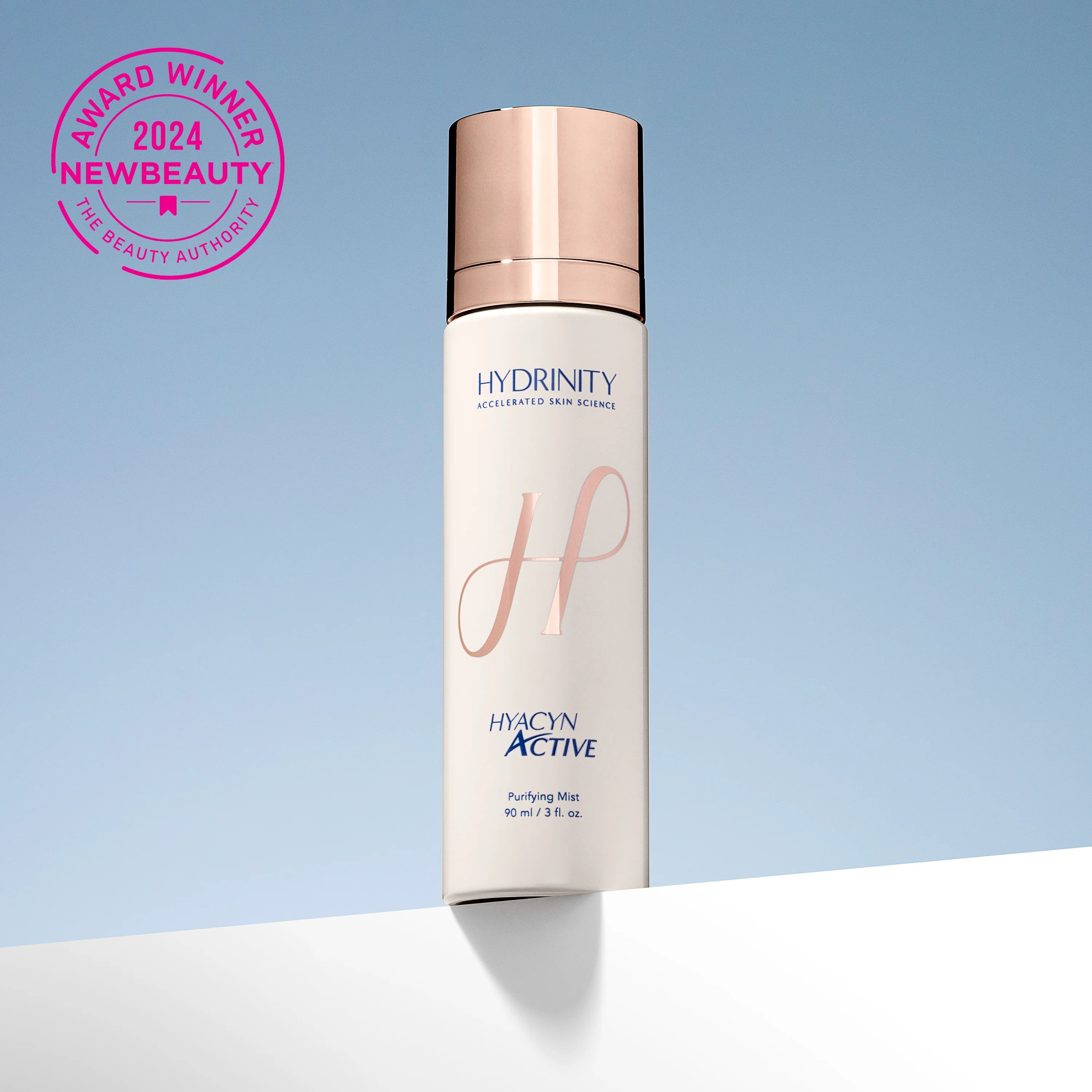 Skincare bottle with rose gold cap and white label on a light blue background, featuring 'Hydrinity' branding. Main image